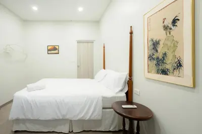 a white bedroom with a bed and a table at xx HD Yaowarat Road BKK in Samphanthawong