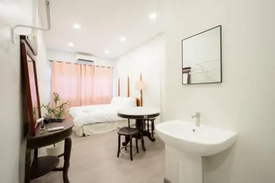 a white bathroom with a sink and a bed at xx HD Yaowarat Road BKK in Samphanthawong