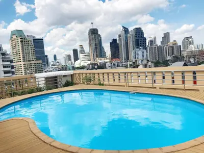 a large swimming pool on top of a building with a city skyline at Charming Resident Sukhumvit 22 in Bangkok