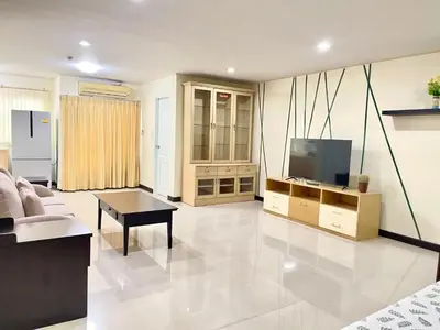 a living room with a couch and a flat screen tv at Charming Resident Sukhumvit 22 in Bangkok