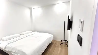 a small white room with a bed in it at 65 Hostel Bangkok in Bangkok Noi