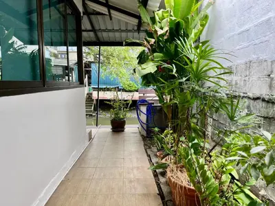 a patio with plants on the side of a building at Kirin Riverside Homestay with AC, WiFi in Bangkok in Rat Burana