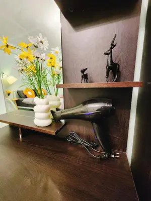 a shelf with a blow dryer and flowers on it at 805-STP Homely room Free Wi-Fi and Near BTS line in Bangkok