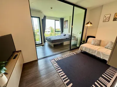 a living room with a bed and a mirror at Modern Condo Near Icon Siam & BTS Krung Thonburi in Bangkok