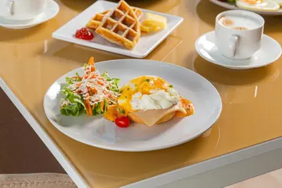 a table with plates of breakfast foods and a cup of coffee at Resort Bangphlat in Bang O