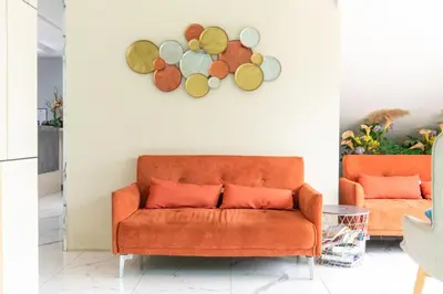 an orange couch in a living room with a wall at Resort Bangphlat in Bang O