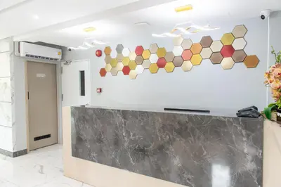 a lobby with a reception counter with colorful tiles on the wall at Resort Bangphlat in Bang O
