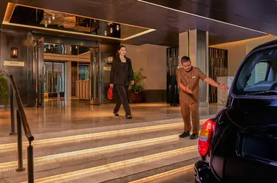 a man and a woman walking down the stairs of a house at Marriott Executive Apartments, Bangkok Townhall Sukhumvit in Bangkok