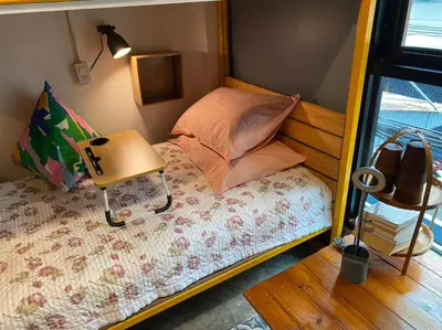 a small bedroom with a bed and a table at The Space Hometel - Women Only in Pom Prap