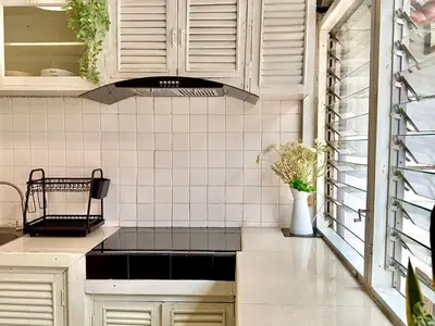 a kitchen with white cabinets and a sink at Flow In House in Bangkok