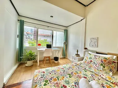 a bedroom with a bed and a desk and a window at Flow In House in Bangkok
