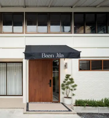 a building with a black awning in front of a door at Baan Jila in Bangkok