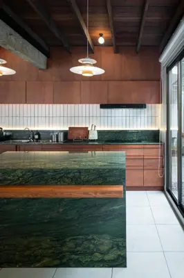 a kitchen with a glass counter top in a room at Baan Jila in Bangkok