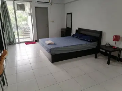 a bedroom with a bed and a large window at Merlin MANSION 107 in Ban Khlong Samrong