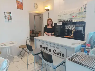 a woman standing behind a counter in a kitchen at Merlin MANSION 107 in Ban Khlong Samrong