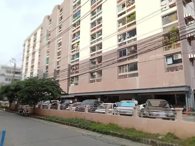 a row of cars parked in front of a tall building at Merlin MANSION 107 in Ban Khlong Samrong