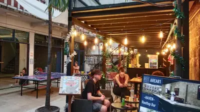 a group of people sitting outside of a restaurant at AREA81 HIDEOUT Hostel Khaosan in Bangkok