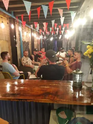 a group of men sitting at a bar in a mirror at AREA81 HIDEOUT Hostel Khaosan in Bangkok