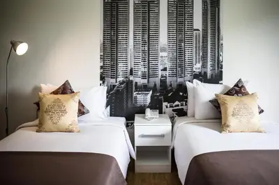 two beds in a hotel room with a view of a city at Anda Ramkhamhaeng By St James Hotel in Bangkok