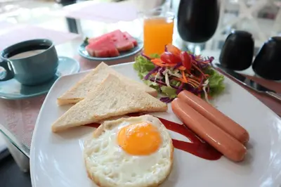 a plate of breakfast food with an egg and toast at Anda Ramkhamhaeng By St James Hotel in Bangkok