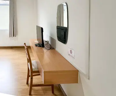 a desk with a tv and a computer on it at Anda Ramkhamhaeng By St James Hotel in Bangkok