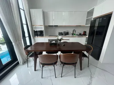 a kitchen with a wooden table and some chairs at Luxury Pool Villa 5BR 12pax with Private Lift in Ekkamai in Bangkok