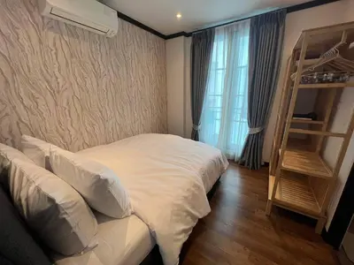 a bedroom with a white bed and a book shelf at Luxury Pool Villa 5BR 12pax with Private Lift in Ekkamai in Bangkok
