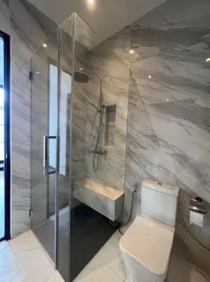 a bathroom with a toilet and a glass shower at Luxury Pool Villa 5BR 12pax with Private Lift in Ekkamai in Bangkok