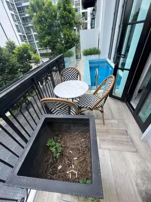 a patio with a table and chairs on a balcony at Luxury Pool Villa 5BR 12pax with Private Lift in Ekkamai in Bangkok