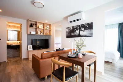 a living room with a table and a couch and a television at Parrish Serviced Apartment in Bang Mote