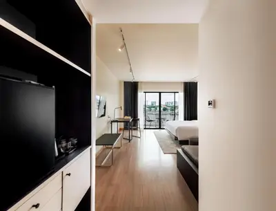 a hotel room with a bed and a television at The StandardX, Bangkok Phra Arthit in Bangkok