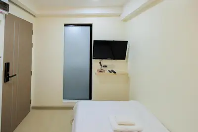 a small room with a bed and a television at Reezq Hostel in Ban Khlong Bang Sai