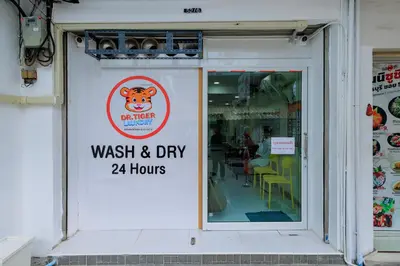 a sign on the door of a wash and dry hours at Reezq Hostel in Ban Khlong Bang Sai