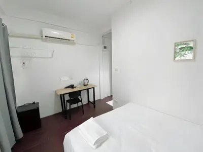 a hotel room with a bed and a desk at GO INN Siriraj - โกอินน์ ศิริราช Pro in Bangkok Noi