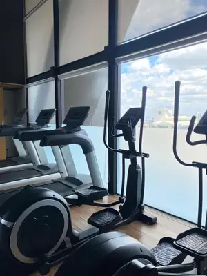 a gym with several tread machines and a large window at Resort Living 2BR - Ultra Fast Wifii - BTS Chong Nonsi in Bangkok