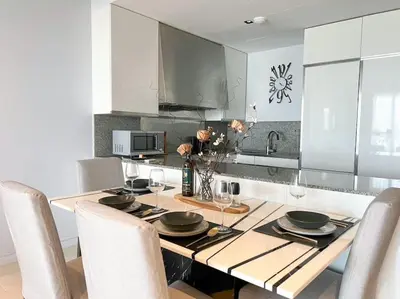 a kitchen with a wooden table with chairs and a dining room at Resort Living 2BR - Ultra Fast Wifii - BTS Chong Nonsi in Bangkok