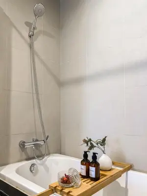 a bathroom with a bath tub with a shower at Deluxe Suite 1BR Ultra Fast WiFi BTS Thong Lor in Bangkok