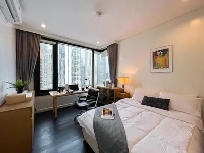 a hotel room with a bed and a desk and window at Expansive Luxury 2BR - Ultra Fast Wifi - Phrom Phong in Bangkok