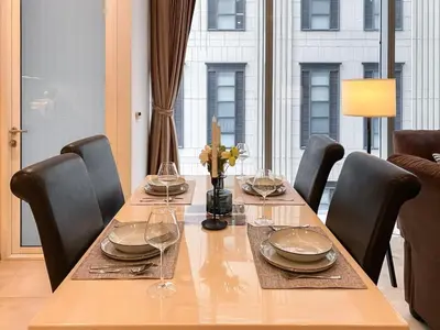 a dining room table with chairs and a large window at Transquil Residents 65 SQM - Ultra Fast Wifi - Silom in Bangkok