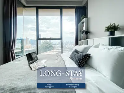 a long stay room with a laptop on a bed at Stylish Riverview 1BR - Ultra Fast WiFi - Phrom Phong in Bangkok