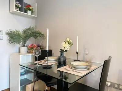 a dining room with a glass table and chairs at Stylish Riverview 1BR - Ultra Fast WiFi - Phrom Phong in Bangkok