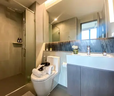 a bathroom with a toilet and a shower and a sink at Stylish Riverview 1BR - Ultra Fast WiFi - Phrom Phong in Bangkok