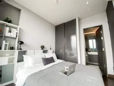 a bedroom with a bed with a laptop on it at Stylish Riverview 1BR - Ultra Fast WiFi - Phrom Phong in Bangkok