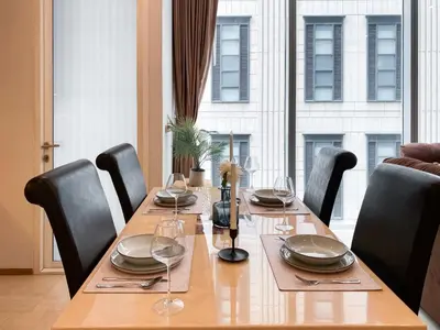 a dining room table with chairs and a large window at Extravagant Apt 65 sqm 1BR - Ultra Fast Wifi - Silom in Bangkok