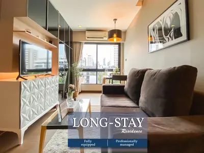 a living room with a couch and a large window at Tropical Haven 1BR - Ultra Fast WiFi - Thong Lo in Bangkok
