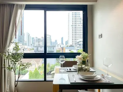 a dining room table with a view of a city at Tropical Haven 1BR - Ultra Fast WiFi - Thong Lo in Bangkok