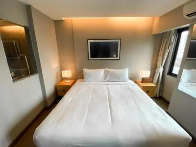 a large white bed in a room with two lamps at Tropical Haven 1BR - Ultra Fast WiFi - Thong Lo in Bangkok