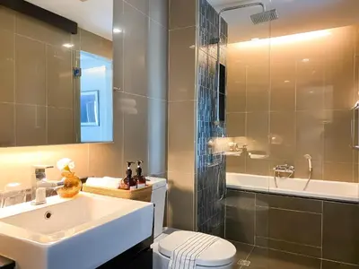 a bathroom with a sink and a toilet and a shower at Tropical Haven 1BR - Ultra Fast WiFi - Thong Lo in Bangkok