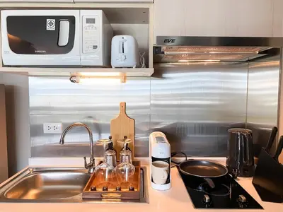 a kitchen counter with a sink and a microwave at Tropical Haven 1BR - Ultra Fast WiFi - Thong Lo in Bangkok