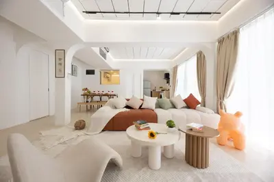 a white living room with a couch and a table at Ratchada Retreat Boutique Suites in Bangkok